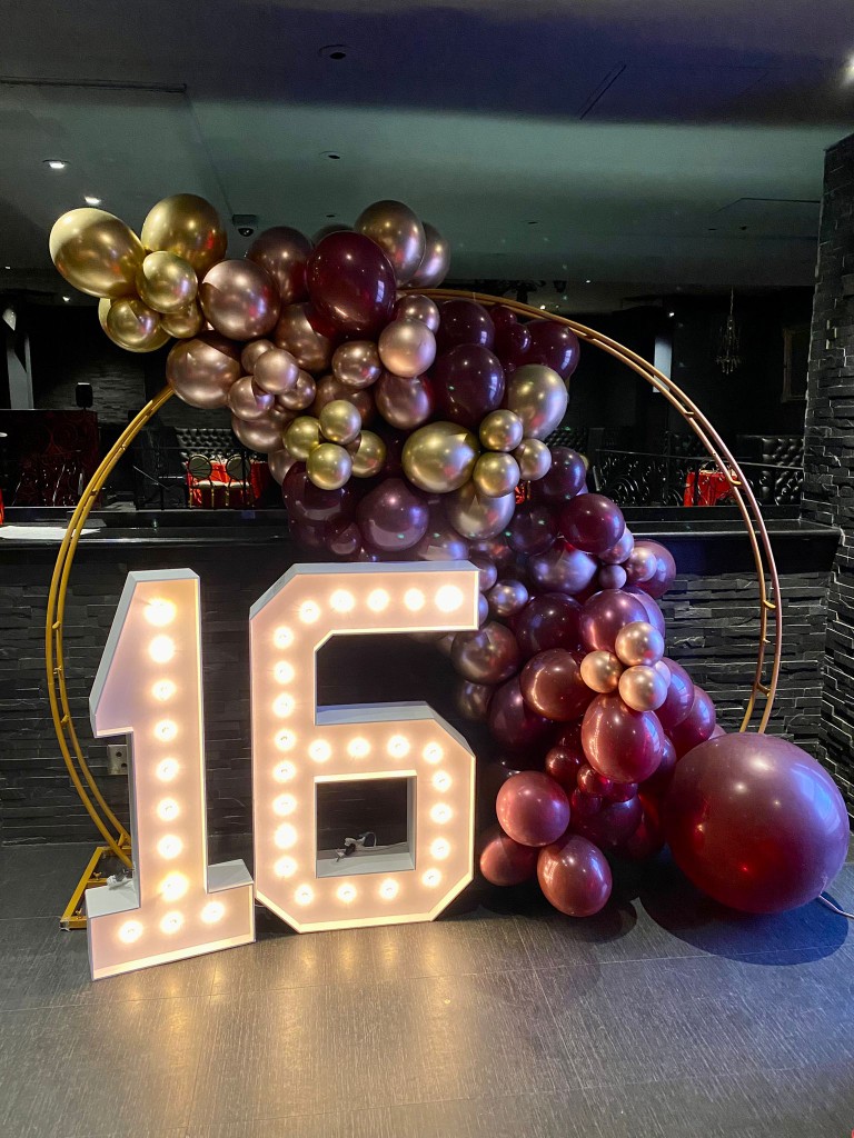 Muskoka balloon decor with marquee numbers and an arch